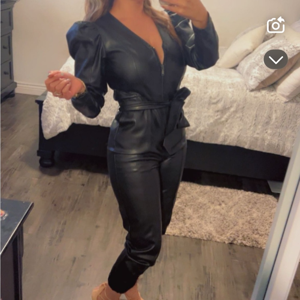 Black leather jumpsuit with deep V-neckline and form-fitting silhouette